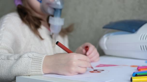 Liten flicka gör inhalationsånga och ritar. Barnet är sjukt och andas genom en inhalator i hemmet. — Stockvideo