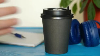 Erkek eli, masadan kahve fincanını al ve git. Öğrenci sabah kahvaltıda cappuccino içiyor..