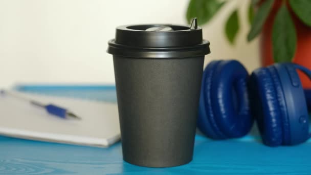 La mano del hombre saca la taza de café con leche de la mesa y vete. Estudiante tomando cappuccino para llevar en la mañana para el desayuno . — Vídeos de Stock