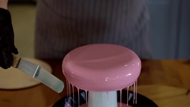 Roze glanzend gieten van de top van handgemaakte taart. Banketbakker bereidt modern Frans mousse dessert met spiegelglazuur. — Stockvideo