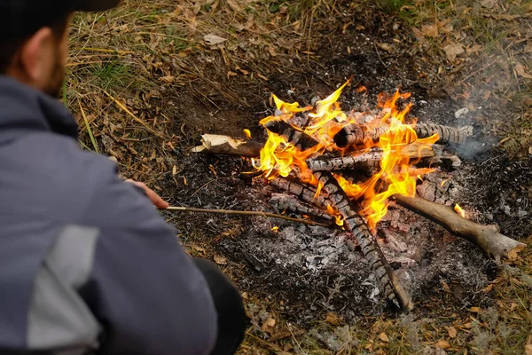 Kamp ateşi külü, yakın görüş. Adam ateş yakıyor..