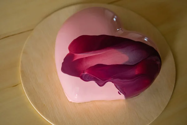 Ahşap tabanlı pembe ayna jöleli modaya uygun kalp kremalı pasta. Modern Avrupa tatlısı.