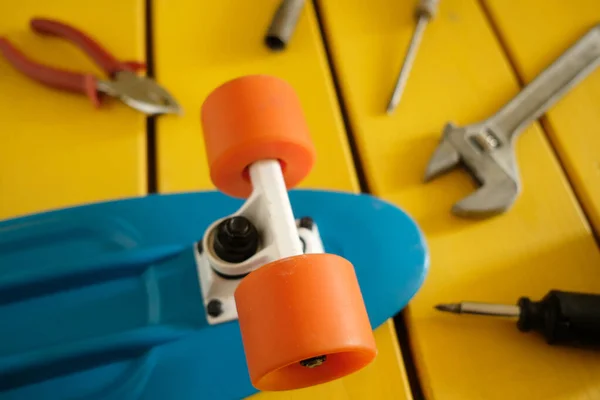 Hizmetteki usta kaykayı tamir ediyor. Genç bir çocuk atölyedeki bir mini kruvazörü tamir edecek. Mini kruvazör.