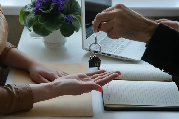 Business woman buys a new apartment. Girl and the agent enters a contract, transfer the keys to the real estate.