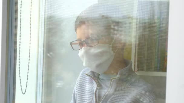 Rapaz Com Uma Máscara Médica Óculos Olha Pela Janela Auto — Vídeo de Stock