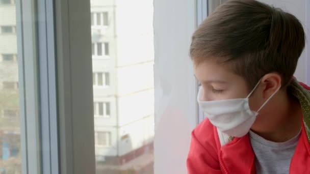 Rapaz Com Uma Máscara Médica Olha Pela Janela Auto Isolamento — Vídeo de Stock