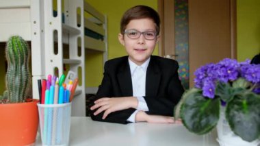 Çocuklar için uzaktan öğrenme. Gözlüklü küçük çocuk karantina sırasında görüntülü konuşma yapıyor..