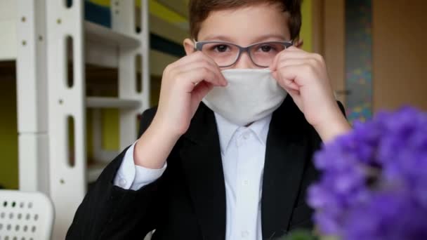 眼鏡をかけた子供が医療用マスクをつけている 隔離における自己分離 コロナウイルス Covid — ストック動画