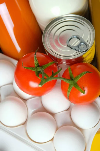 Sarı arka planda bir kutuda yiyecek seti. Karantina ve koronavirüs sırasında gıda bağışları.