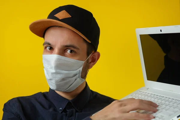 Bilgisayarlı, tıbbi maskeli bir adam internetten alışveriş öneriyor..