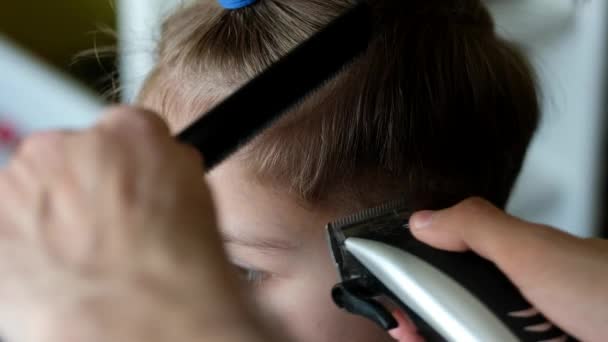 Il barbiere taglia i capelli a un ragazzino con un clipper a casa. Autoisolamento, quarantena, coronavirus, covd 19 . — Video Stock