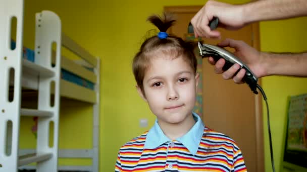 Um rapaz lindo numa barbearia. Pai cortando cabelo de filho pequeno com clipper. Coronavírus, quarentena, covid19 . — Vídeo de Stock