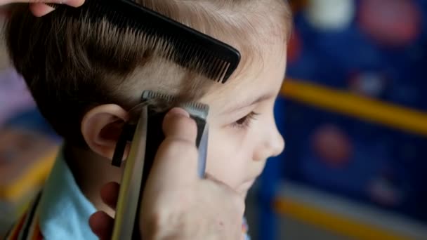 Friseur schneidet einem kleinen Jungen zu Hause mit einem Haarschneider die Haare. Selbstisolierung, Quarantäne, Coronavirus, Covid 19. — Stockvideo