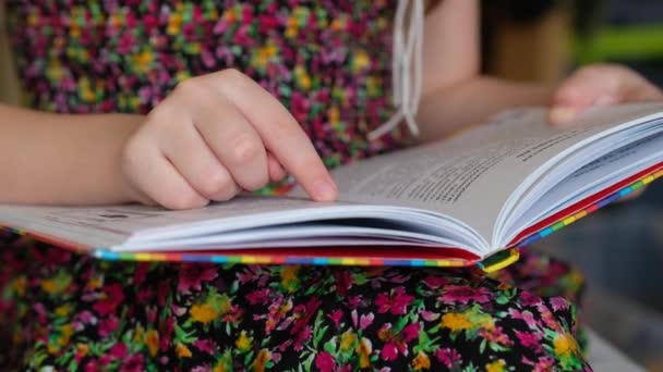 Κοριτσάκι Πολύχρωμο Φόρεμα Διαβάζει Ένα Βιβλίο Παιδί Μαθαίνει Διαβάζει — Αρχείο Βίντεο