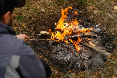 Kamp ateşi külü, yakın görüş. Adam ateş yakıyor..