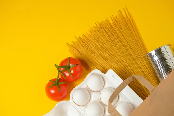 Food donations on a yellow background. Social assistance. Copy space.