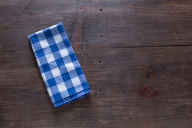 Ahşap masa arka plan mavi kumaş peçete ile.
