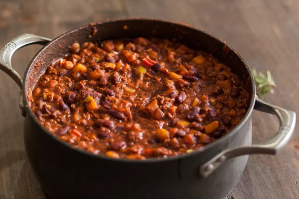 Chili vegetariano orgánico en maceta de hierro servido con romero —  Fotos de Stock