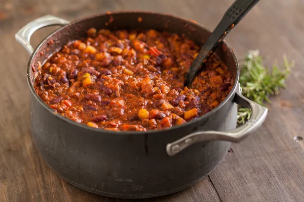 Chili vegetariano orgánico en maceta de hierro servido con romero —  Fotos de Stock