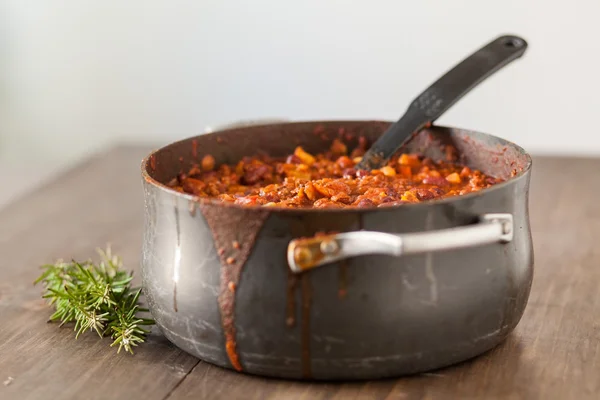 Chili vegetariano orgánico en maceta de hierro servido con romero —  Fotos de Stock