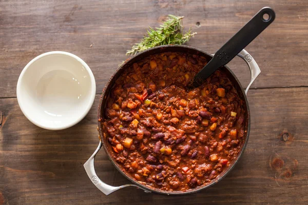 Chili vegetariano orgánico en maceta de hierro servido con romero —  Fotos de Stock