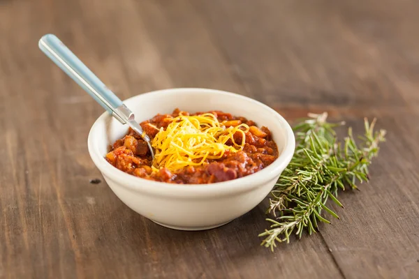 Un tazón caliente de chile vegetariano orgánico picante con queso derretido —  Fotos de Stock