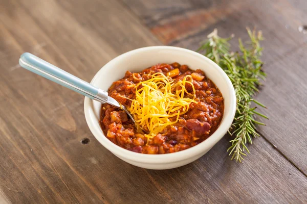 Un castron fierbinte de picant organic vegetarian chili cu brânză topită — Fotografie, imagine de stoc