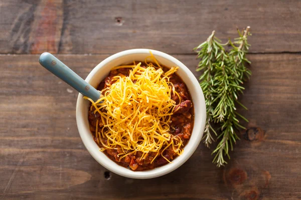 Un tazón caliente de chile vegetariano orgánico picante con queso derretido —  Fotos de Stock