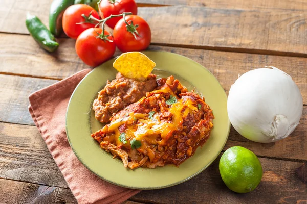 Cazuela de comida mexicana Enchilada de pollo servida en placa verde rústica —  Fotos de Stock