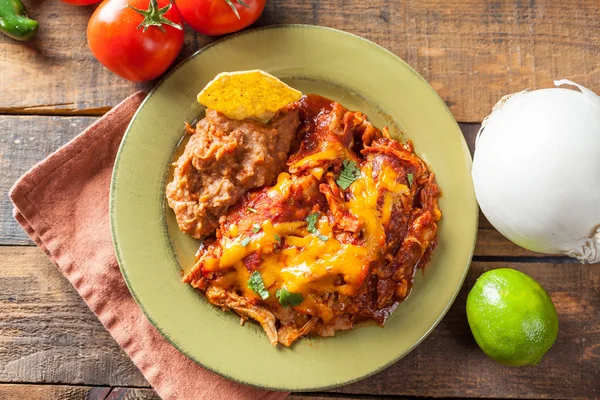 Cazuela de comida mexicana Enchilada de pollo servida en placa verde rústica —  Fotos de Stock