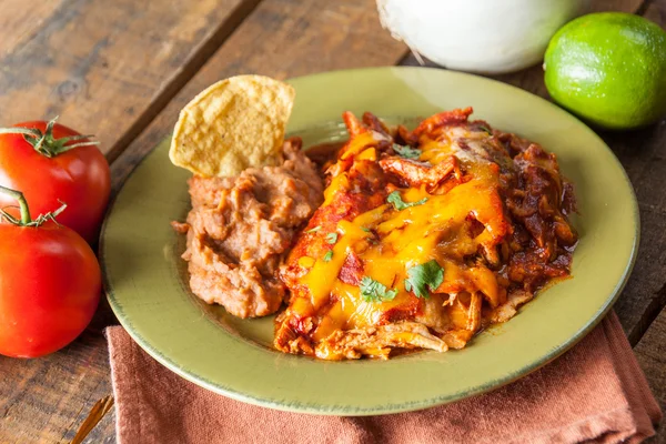 Cazuela de comida mexicana Enchilada de pollo servida en placa verde rústica —  Fotos de Stock