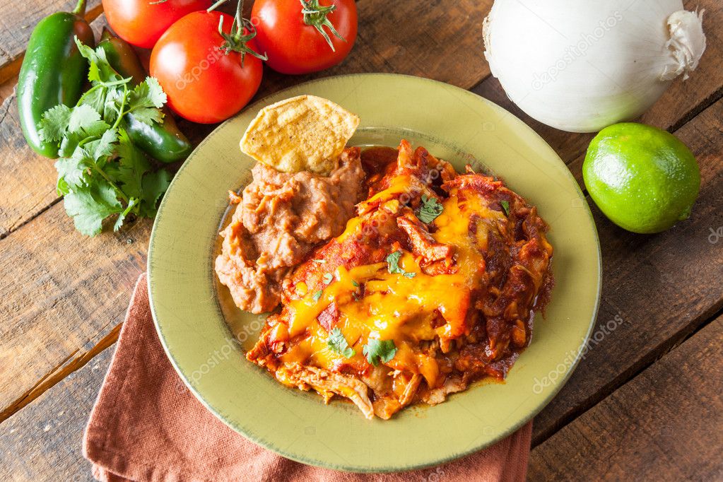 Cazuela de comida mexicana Enchilada de pollo servida en placa verde