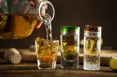 Bardak tekila ahşap masa üzerinde. Seçici odak.