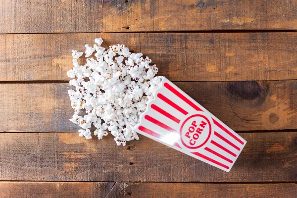 Popcorn in klassischer Kino-Servierbox auf Holz-Hintergrund — Stockfoto