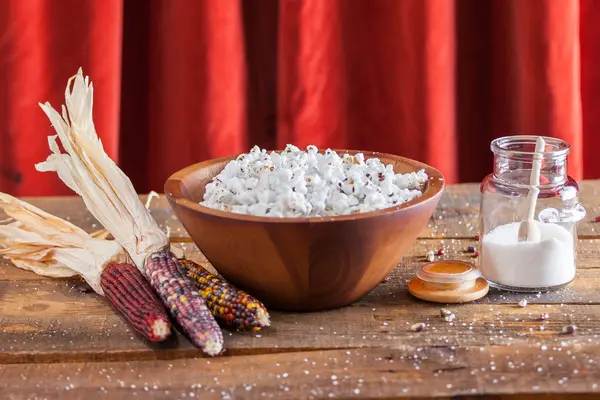 Frisch geknalltes Popcorn in Holzschale mit Kernen und Maiskolben — Stockfoto