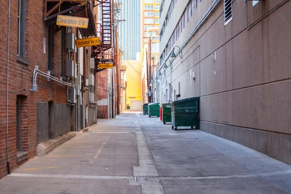 Brick alleyway with dumpsters and fire escape and copy space. — Stock Photo, Image