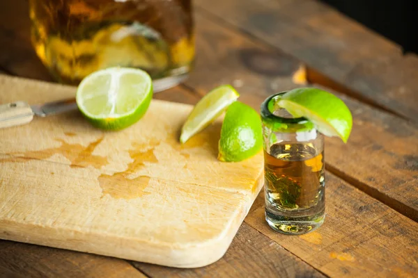 Un vaso de tequila con botella. Enfoque selectivo. Fondo borroso . — Foto de Stock