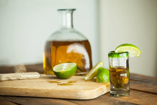 Un vaso de tequila con botella. Enfoque selectivo. Fondo borroso . — Foto de Stock