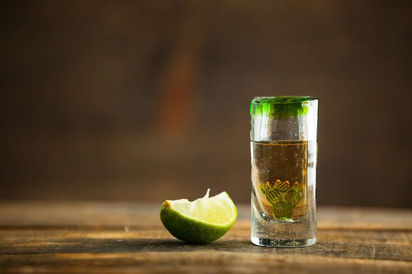 Un bicchierino di tequila sul tavolo di legno. Focus selettivo . — Foto Stock