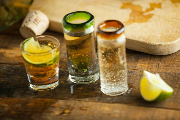 Un vaso de tequila sobre una mesa de madera. Enfoque selectivo . — Foto de Stock