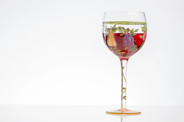 Copa de vino tinto sobre fondo blanco con flores y espacio para copiar — Foto de Stock