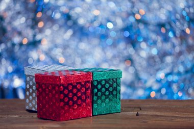 Küçük renkli Noel hediye kutuları ahşap arka plan üzerinde.