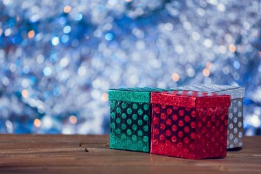 Küçük renkli Noel hediye kutuları ahşap arka plan üzerinde.
