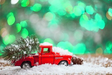 Noel oyuncak kamyon ile çam ağacı üzerinde yeşil arka plana sahip ahşap masa.