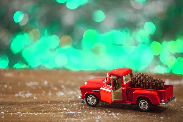 Caminhão de brinquedo de Natal com cone de pinho na mesa de madeira — Fotografia de Stock