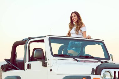 Güzel mutlu gülümseyen genç bayan Cabrio araba poz ayakta.