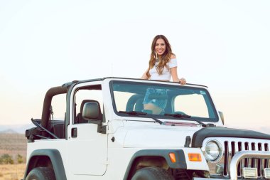 Güzel mutlu gülümseyen genç bayan Cabrio araba poz ayakta.