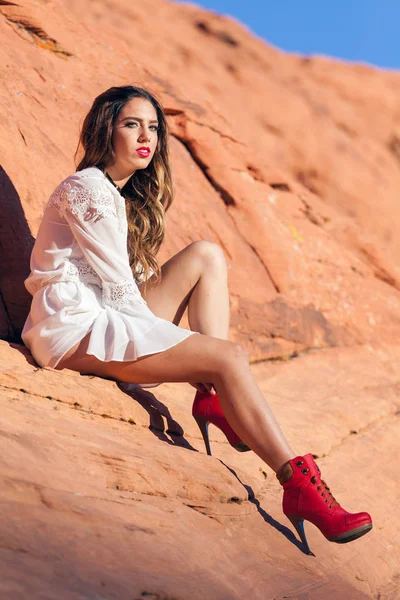 Güzel genç Amerikalı Model giyen beyaz baştan çıkarıcı kırmızı kayalık çölde. — Stok fotoğraf