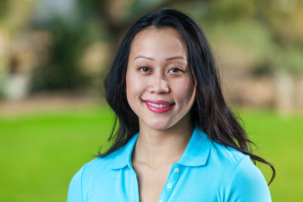 Portrait Of Young Asian Woman Smiling Wearing Blue Polo Shirt
