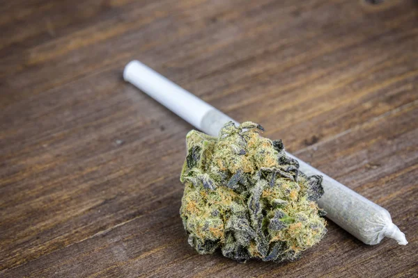 Macro Close Up Of Marijuana Bud With Joint On Wooden Table. Selective Focus With Copy Space. — Stock Photo, Image